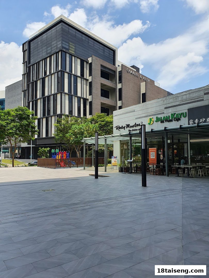 Exterior view of Rocky Master and Jalan Kayu shops with outdoor seating, a plaza, and a modern building.