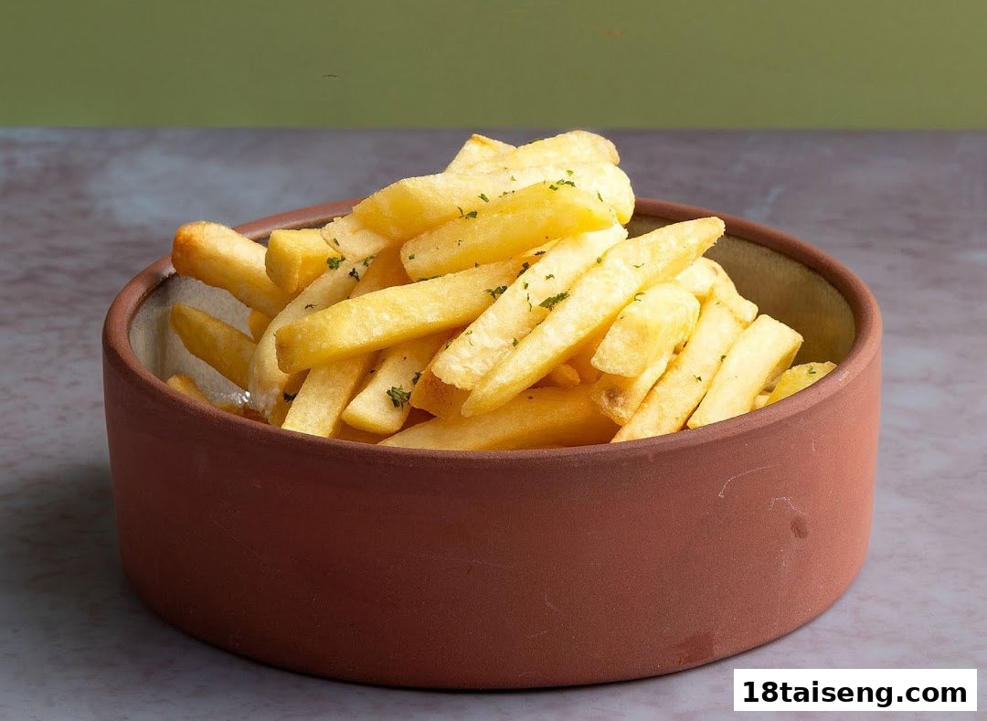 A bowl of golden french fries sprinkled with green herbs, presented in a rustic brown bowl.