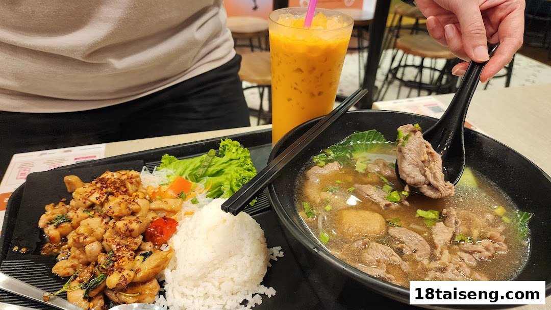 A delicious Thai meal featuring basil chicken rice, beef noodle soup, and Thai iced tea.