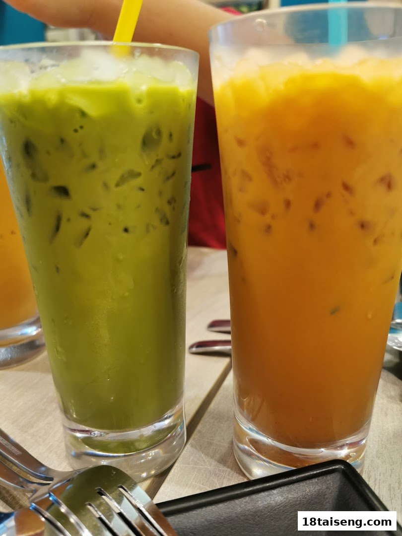 Two refreshing iced drinks, one green and one orange, on a table.