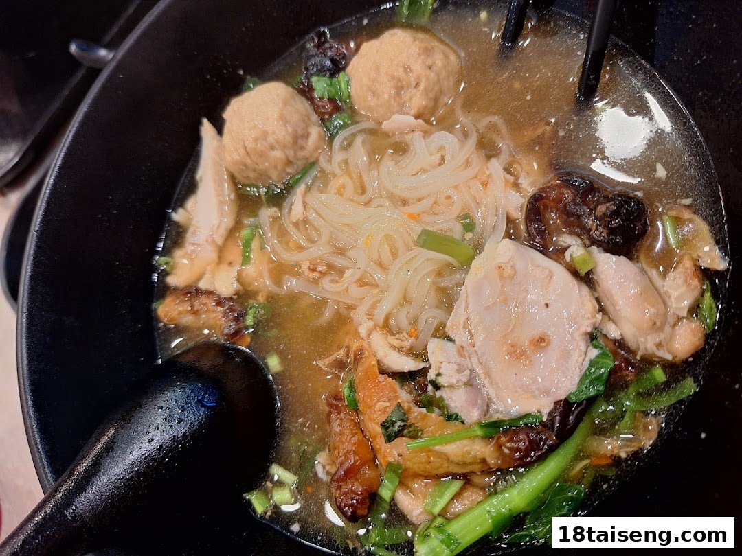 A close-up of a delicious bowl of Thai boat noodles with various toppings.