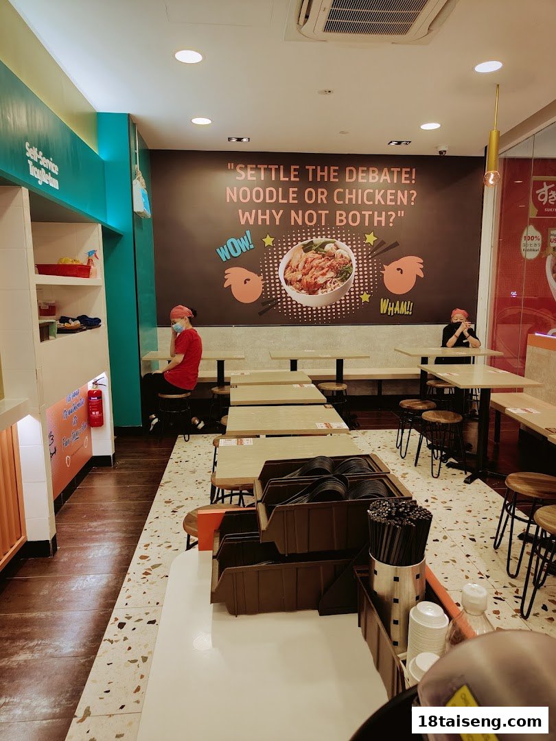 Interior of Saap Saap Thai restaurant featuring seating, a self-service area, and a playful wall graphic.