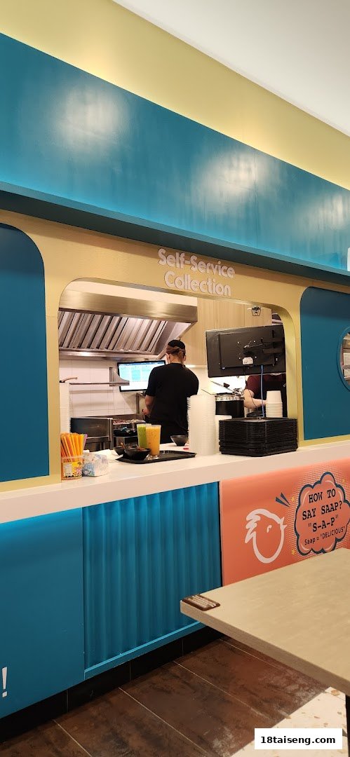 A staff member prepares food at the self-service collection counter of Saap Saap Thai.