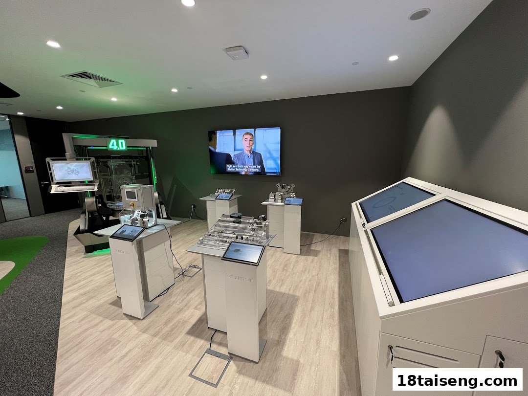 An interior view of Schaeffler Singapore's innovation space with interactive technology displays and a large screen.