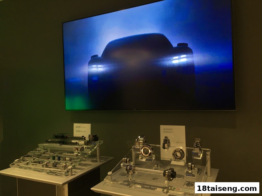 An interior view of Schaeffler Singapore showcasing industrial components and automotive technology on a large screen.