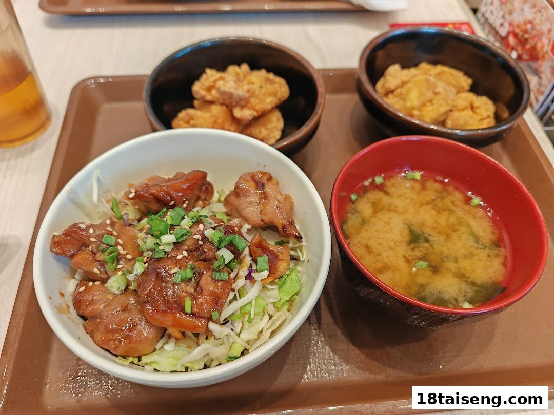 A delicious Japanese meal set featuring a teriyaki chicken rice bowl, miso soup, and crispy fried chicken.