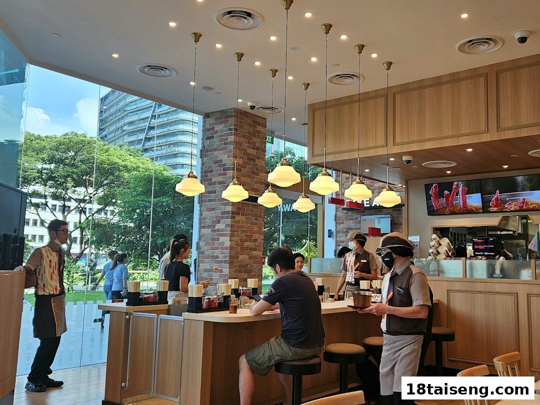 Interior view of Sukiya restaurant showing customers dining at a counter and staff serving.