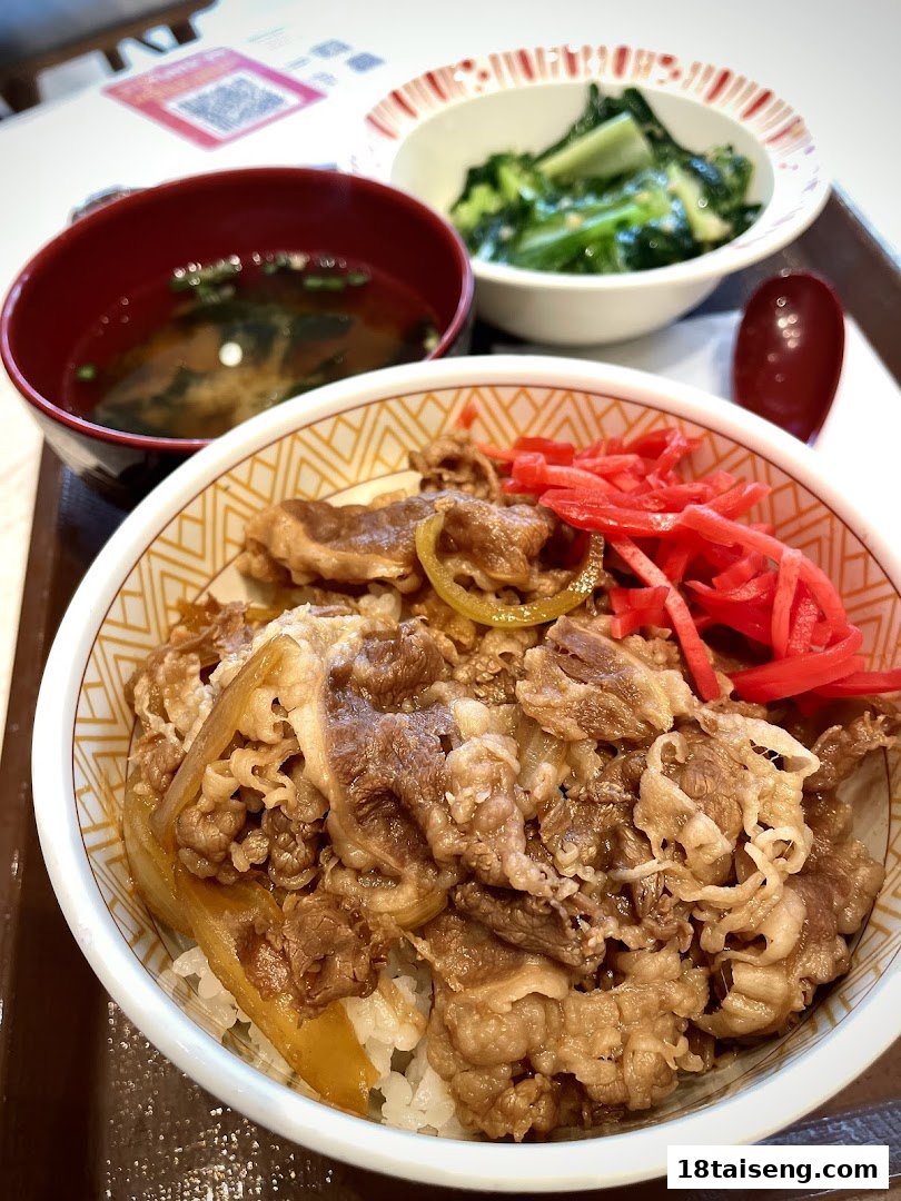 A delicious Sukiya gyudon set meal with beef, rice, soup, and a vegetable side.