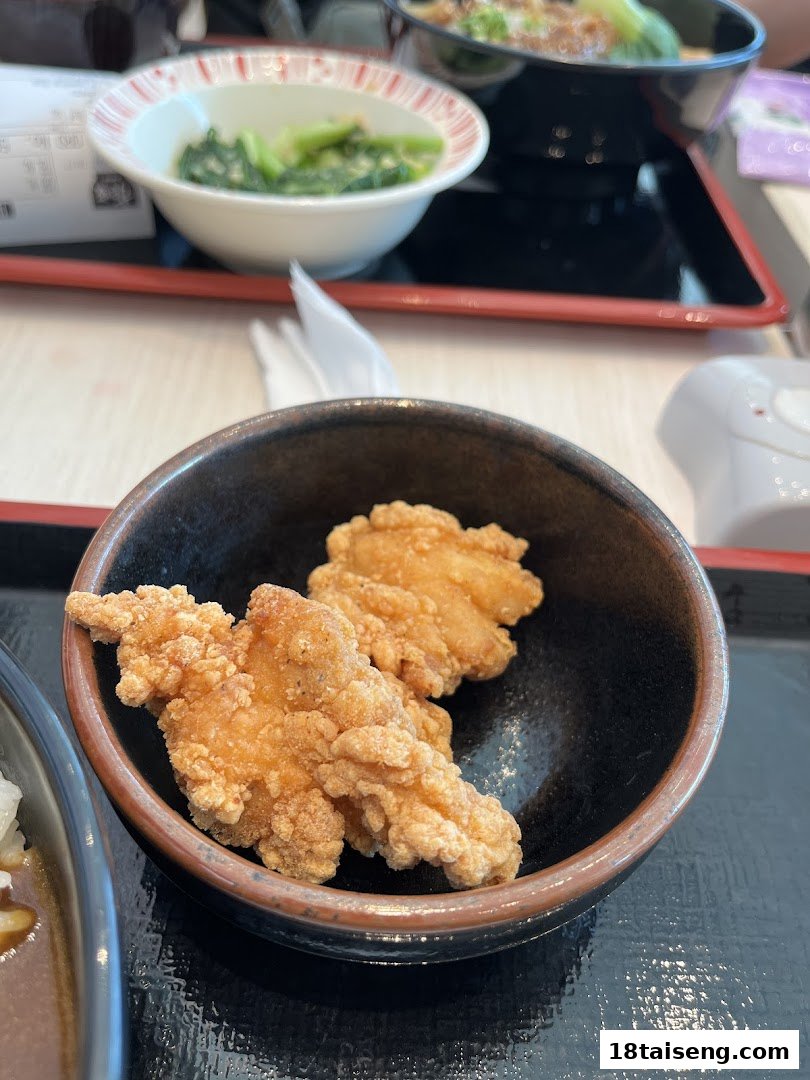 Close-up of crispy fried chicken in a bowl, part of a meal at Sukiya.