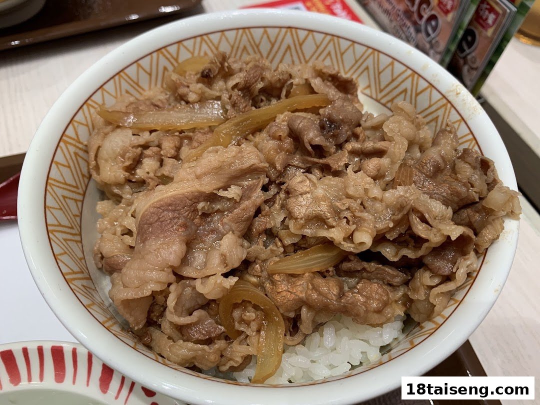 A close-up of a Sukiya Gyudon (beef bowl) with rice and onions.
