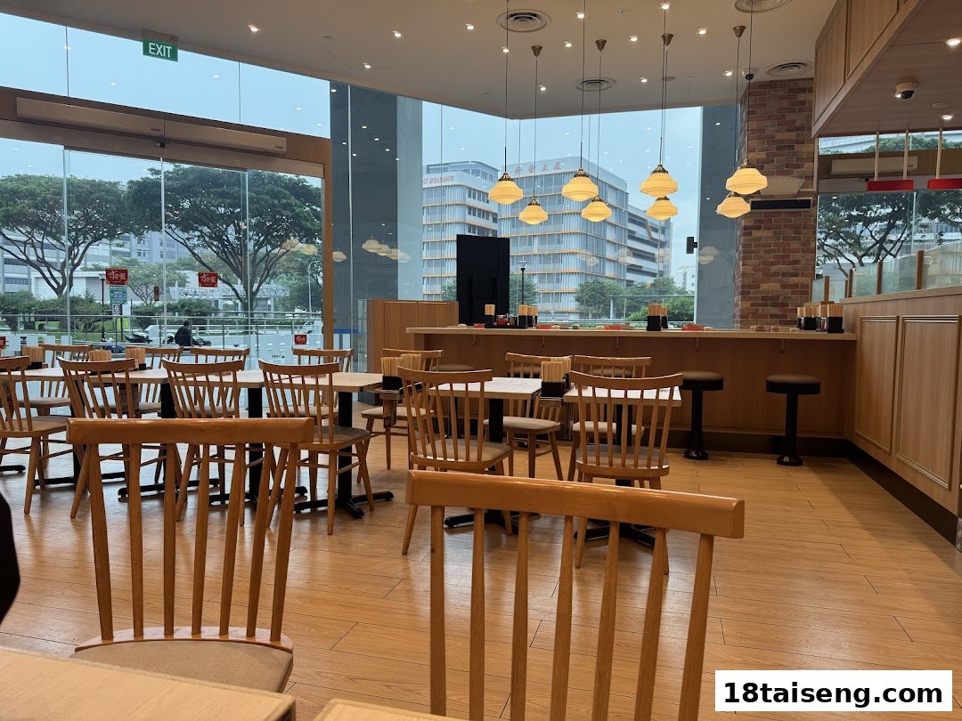 Interior view of Sukiya restaurant featuring wooden tables, chairs, and large windows.
