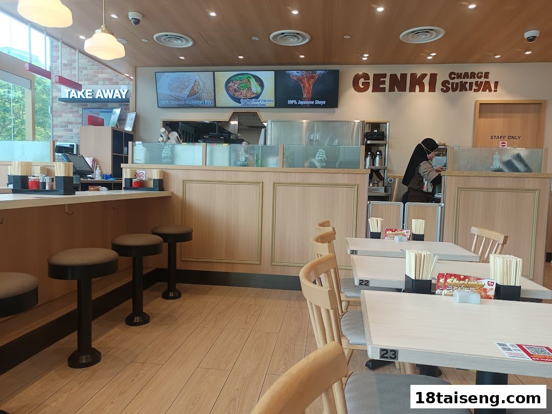 Interior view of Sukiya Gyudon & Curry, showing dining area, counter, and digital menu displays.