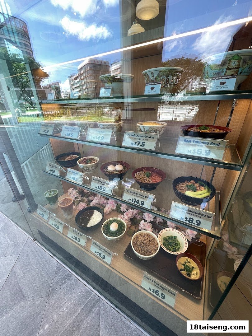 A display case showcasing various Japanese rice bowls, curries, and drinks with prices.
