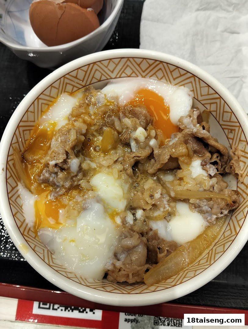 A close-up of a delicious gyudon bowl with tender beef, onions, and a soft-boiled egg.