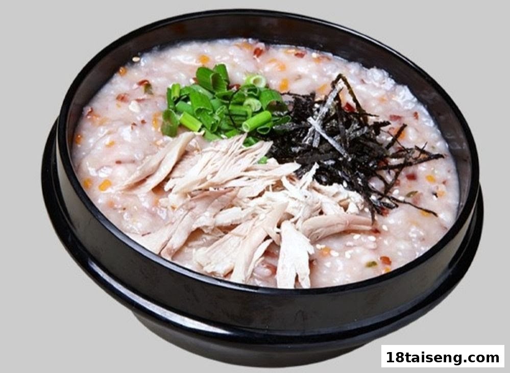 A comforting bowl of Korean chicken porridge (Juk) topped with shredded chicken, green onions, and seaweed.