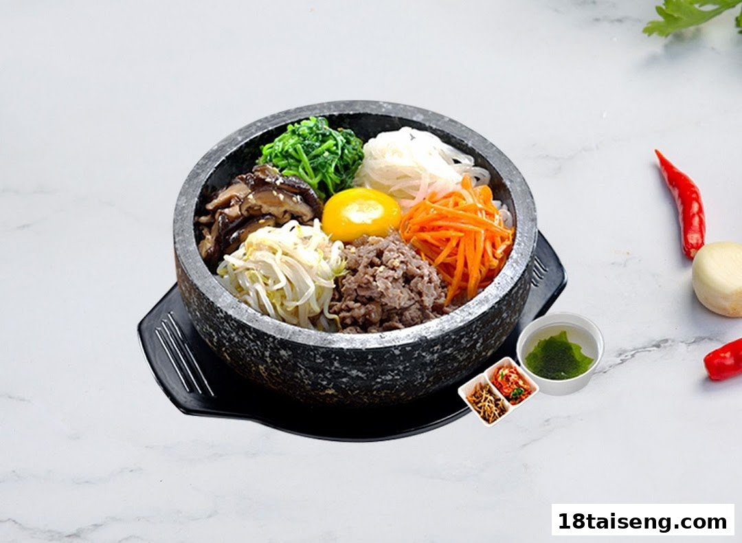 A vibrant Korean bibimbap in a hot stone bowl, served with side dishes and fresh ingredients.