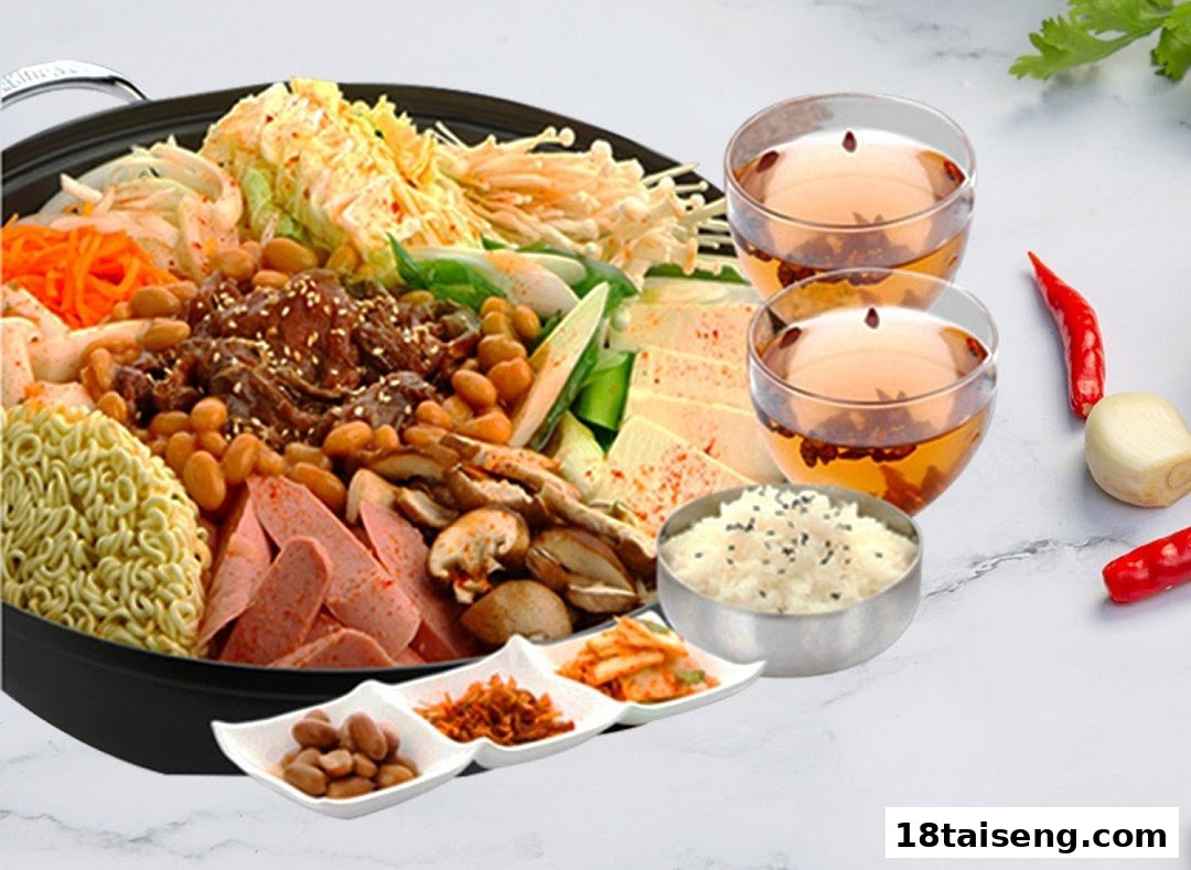 A vibrant Korean hot pot (Budae Jjigae) with various ingredients, side dishes, rice, and tea.