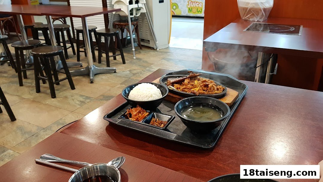 A delicious Korean meal set with rice, soup, and side dishes on a table in a restaurant.