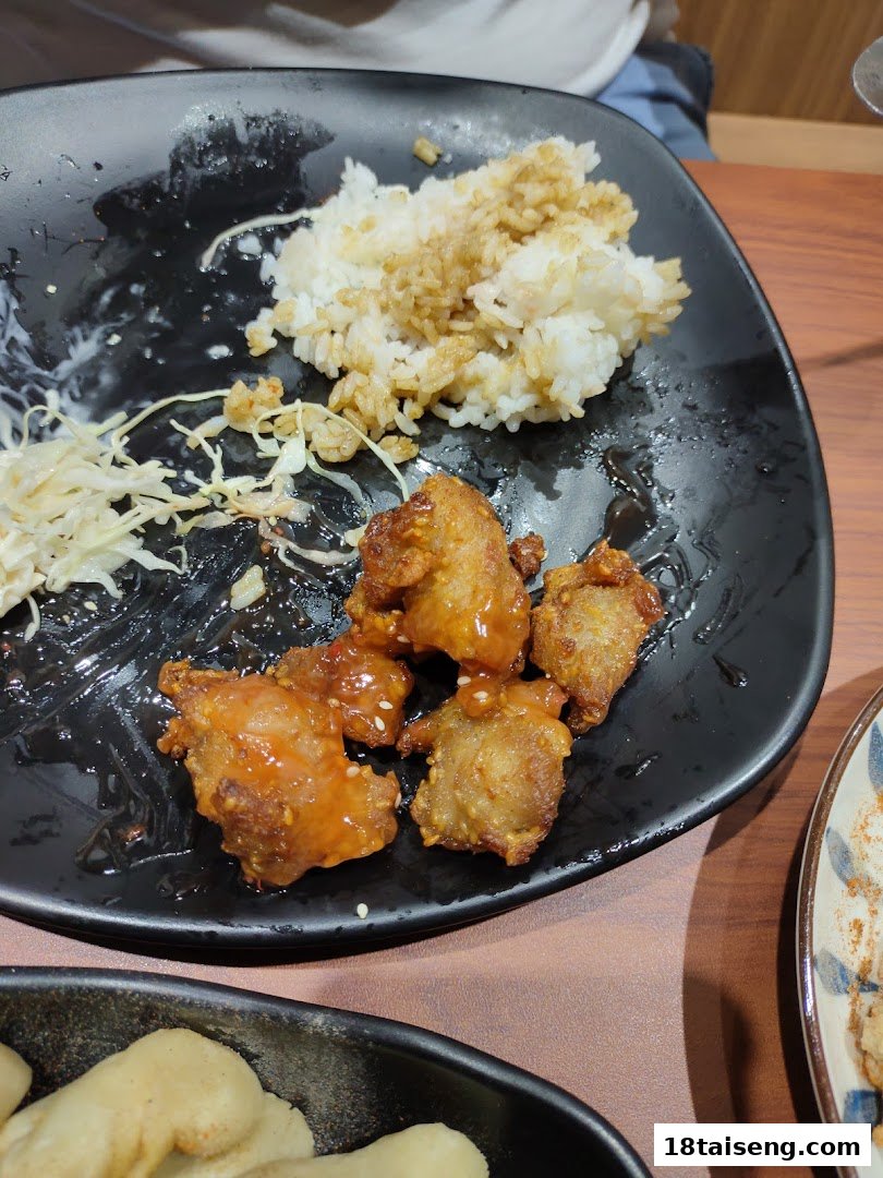 A plate of sauced fried chicken with white rice and shredded cabbage, served at Taiwan Ichiban.