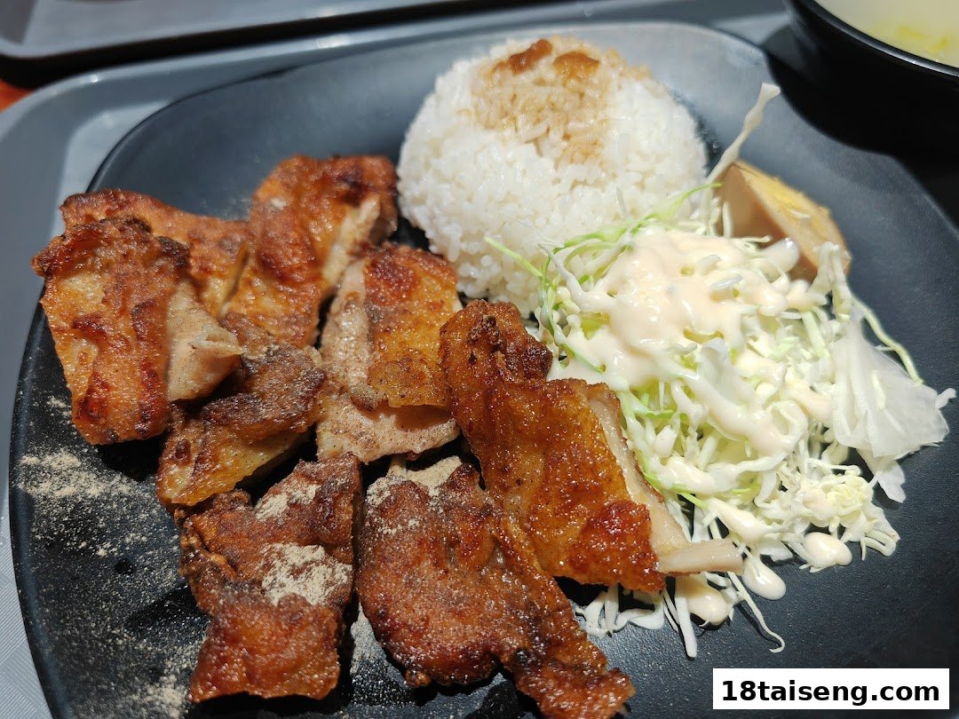 A delicious plate featuring crispy fried chicken, fluffy white rice, and a fresh cabbage salad.