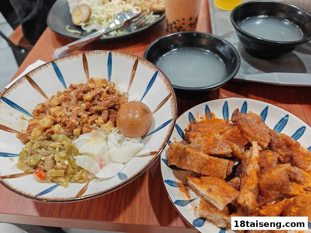 A close-up of delicious Taiwanese dishes, including braised pork rice and crispy fried pork, served on a wooden table.