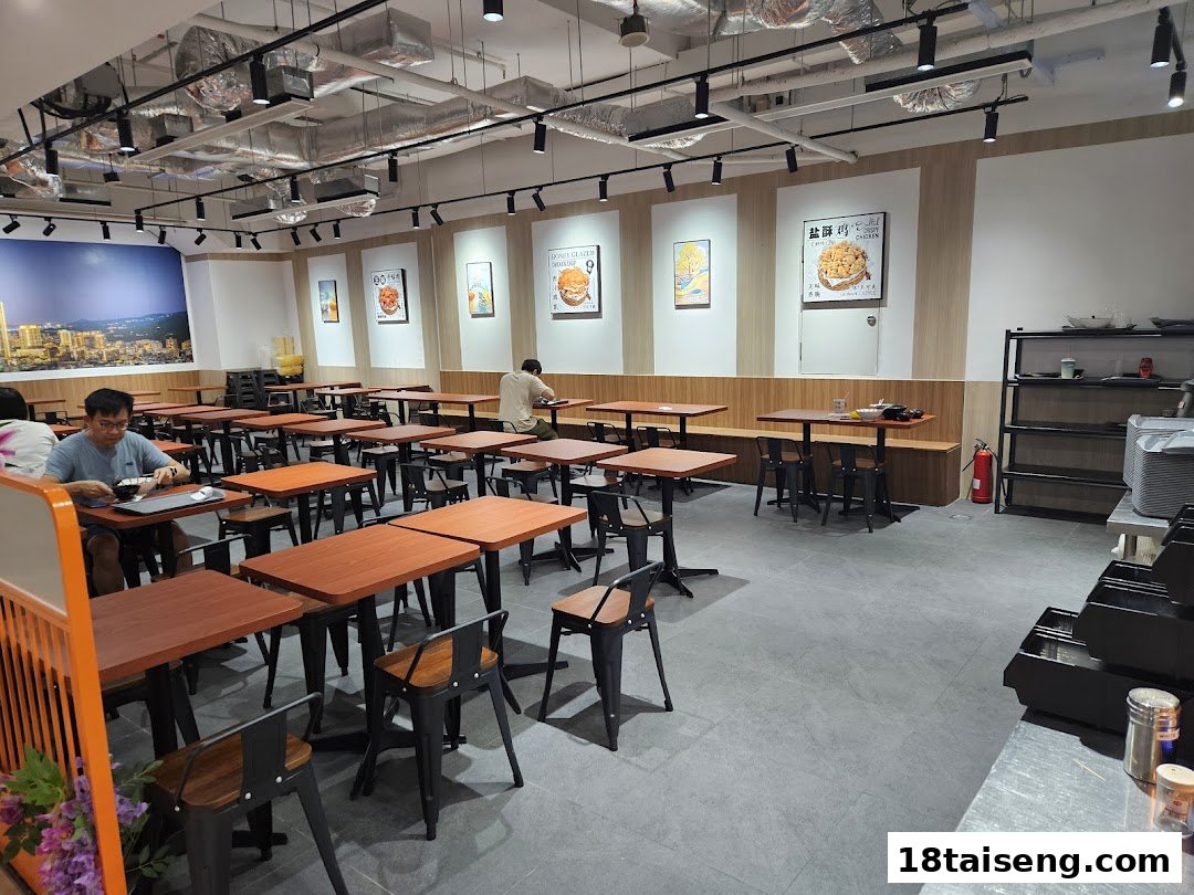 Spacious interior of Taiwan Ichiban restaurant with wooden tables, black chairs, and customers dining.