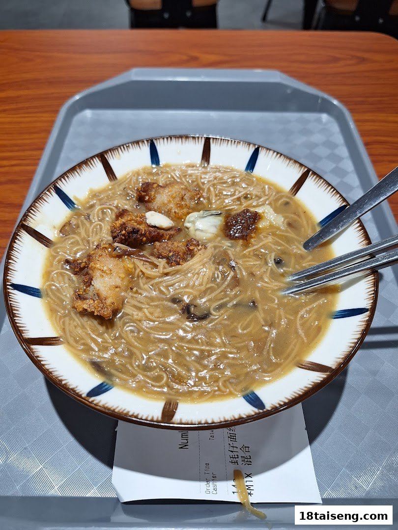 A close-up of a delicious bowl of Taiwanese vermicelli with fried pork and oysters, served on a tray.