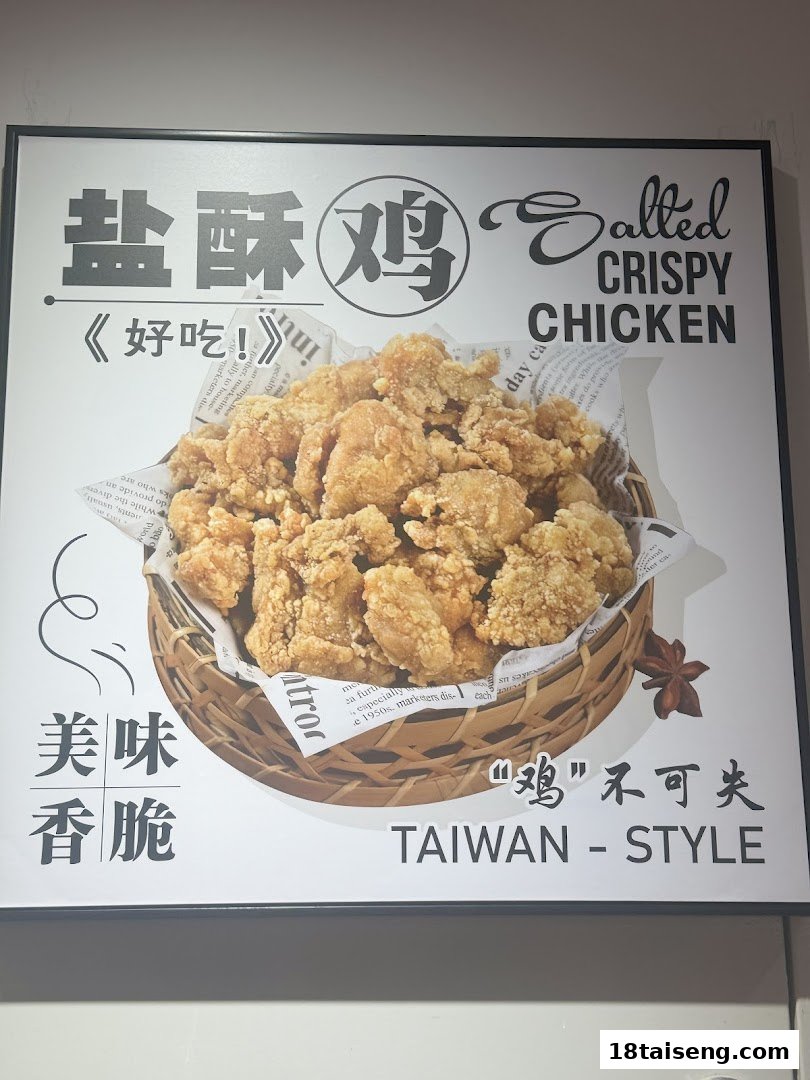 A promotional sign featuring a large image of salted crispy chicken in a basket, with Chinese and English text.