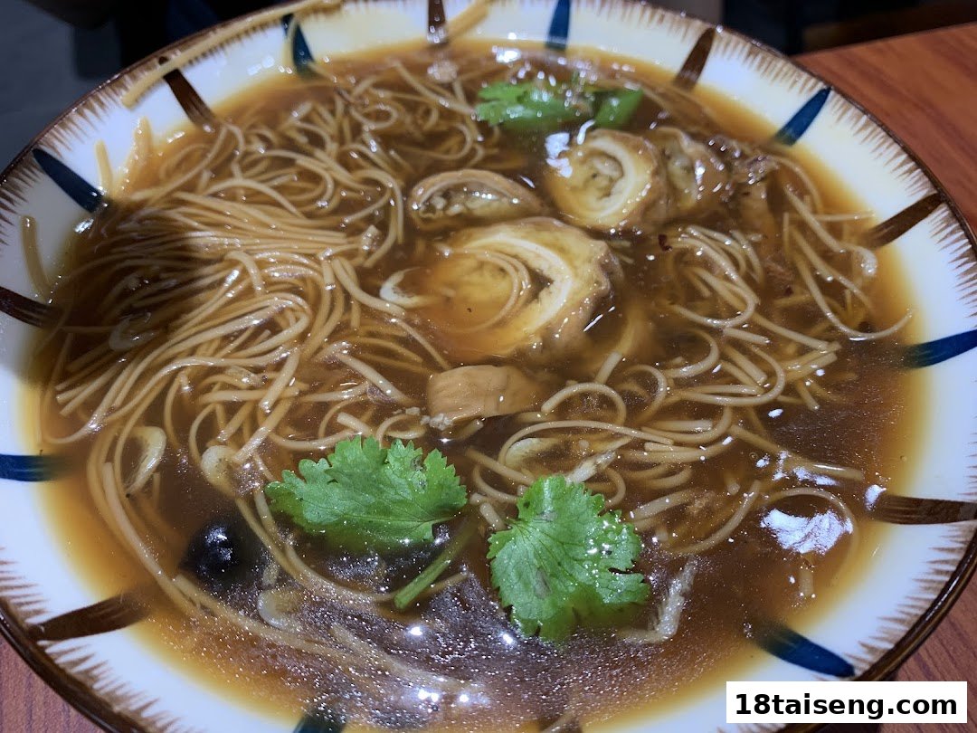 A close-up of a delicious bowl of Taiwanese vermicelli with braised intestines and cilantro.