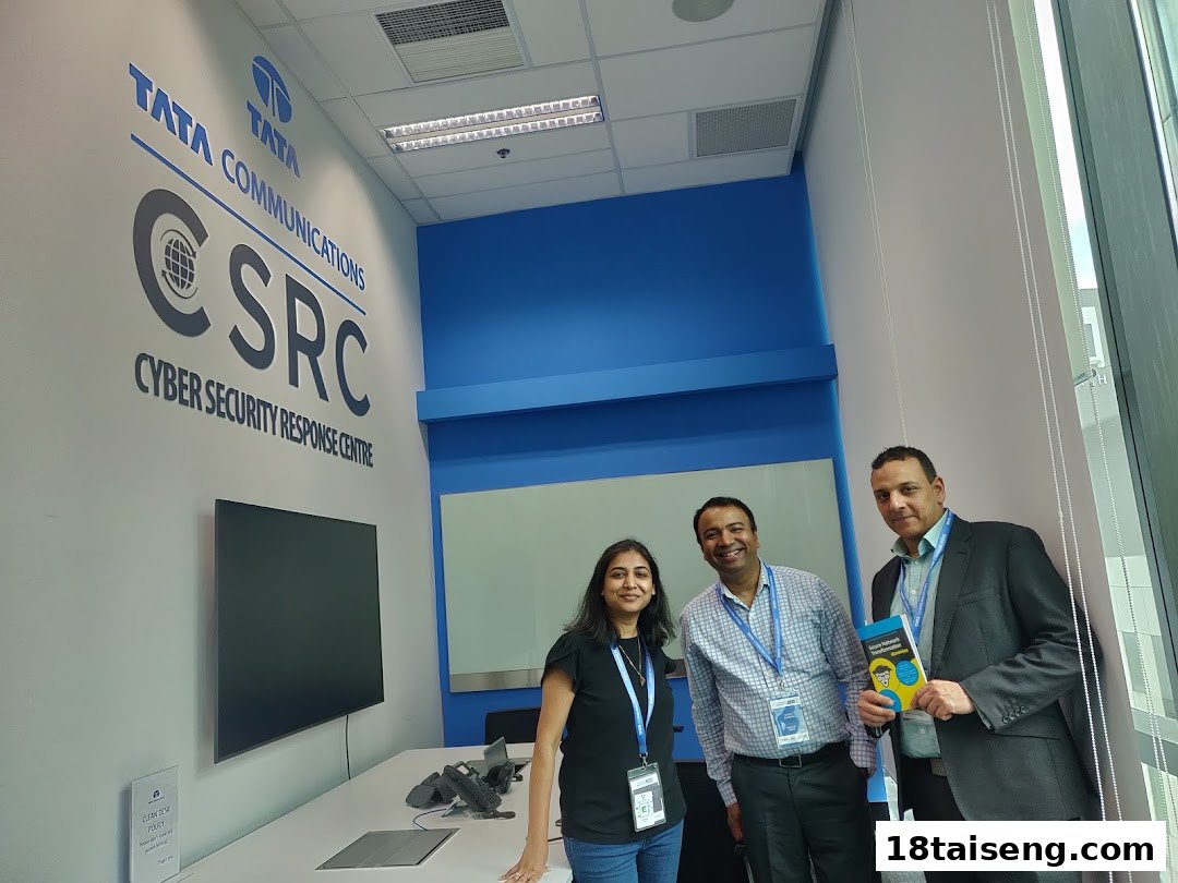 Three professionals stand in the Tata Communications Cyber Security Response Centre office, featuring the CSRC logo.