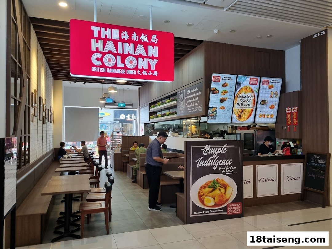 Interior view of The Hainan Colony, a British Hainanese diner, showing seating, counter, and menu displays.
