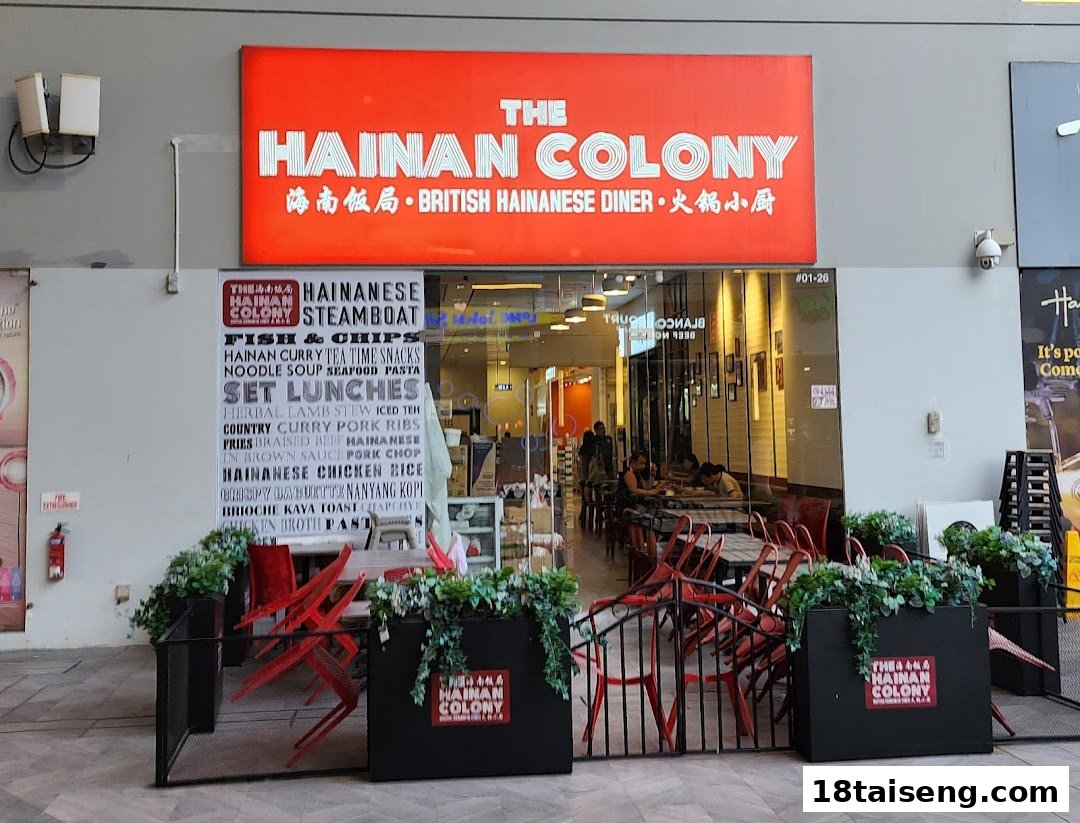 The storefront of The Hainan Colony, a British Hainanese diner, featuring its vibrant red signage and entrance.