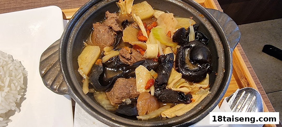 A hearty claypot dish featuring tender meat, various mushrooms, and vegetables, served with white rice.