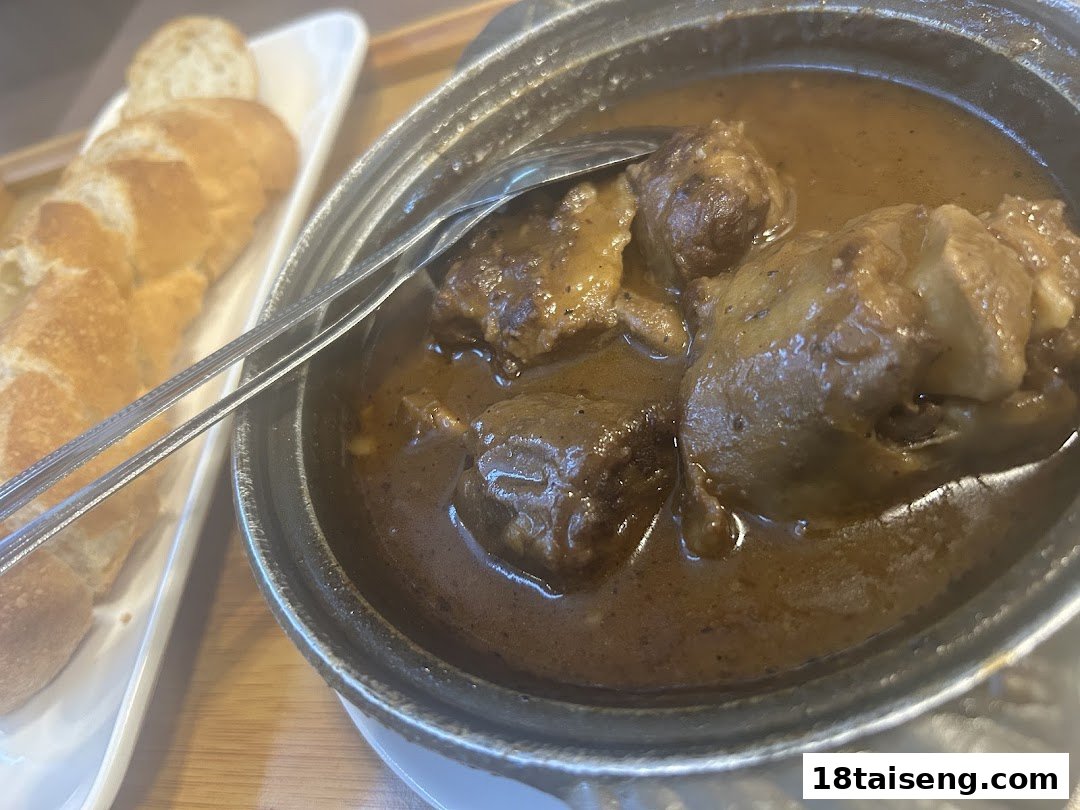A hearty stew or curry with tender meat and potatoes, served with crusty bread on the side.
