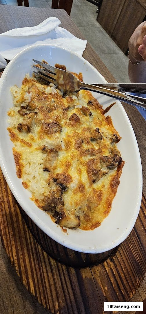 A close-up of a delicious baked rice dish with melted cheese and savory toppings.