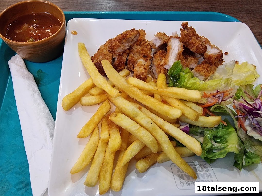 A plate of crispy fried chicken, golden fries, fresh salad, and a side of soup.