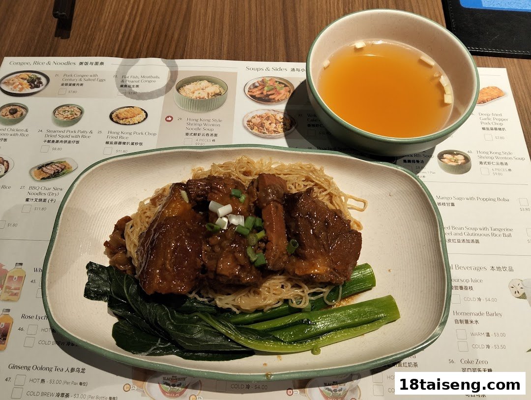 A delicious plate of braised beef noodles with greens and a side of soup, set against a restaurant menu.