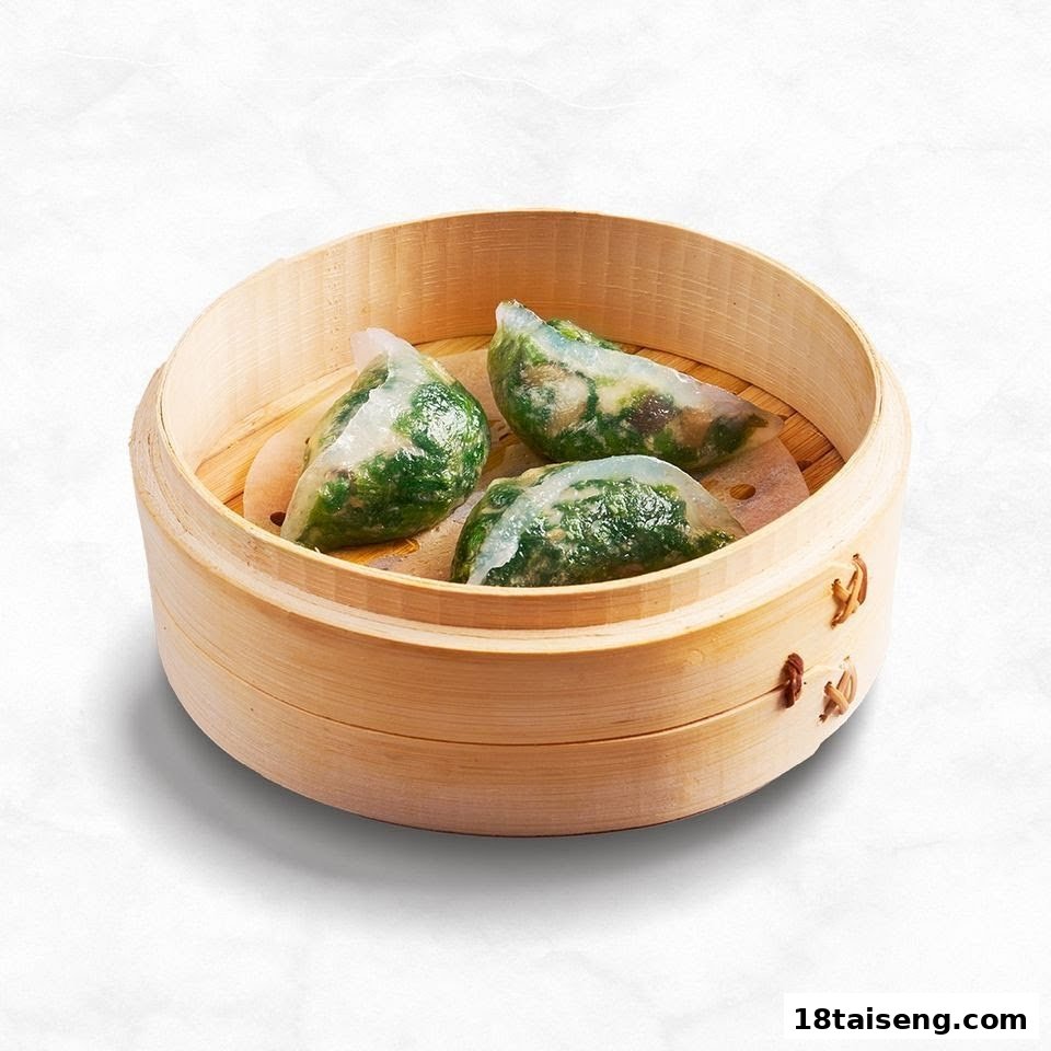 Three steamed dumplings with green filling in a bamboo steamer.