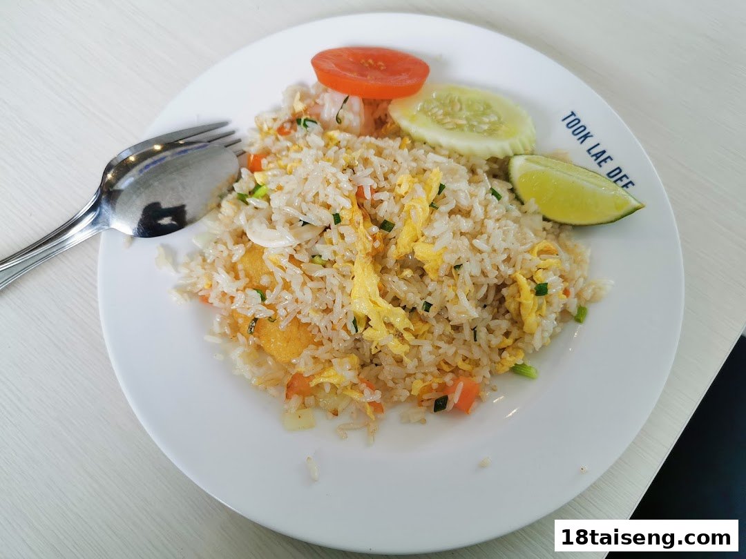 A plate of delicious fried rice with vegetables, egg, and lime, served at Took Lae Dee.