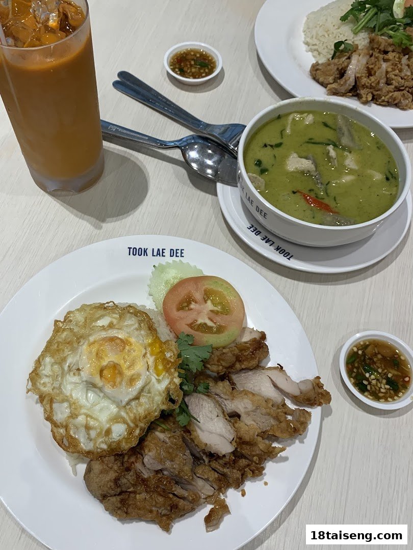 Delicious Thai dishes including fried chicken with rice, green curry, and iced tea.