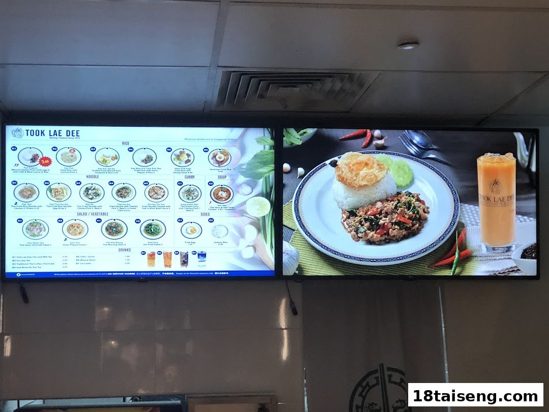 Digital menu board displaying a variety of Thai dishes and drinks with prices at Took Lae Dee.