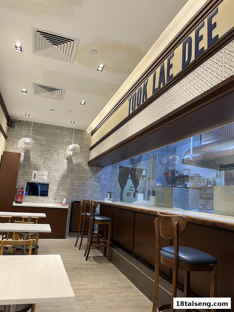 Interior view of Took Lae Dee restaurant featuring seating, a counter, and an open kitchen.