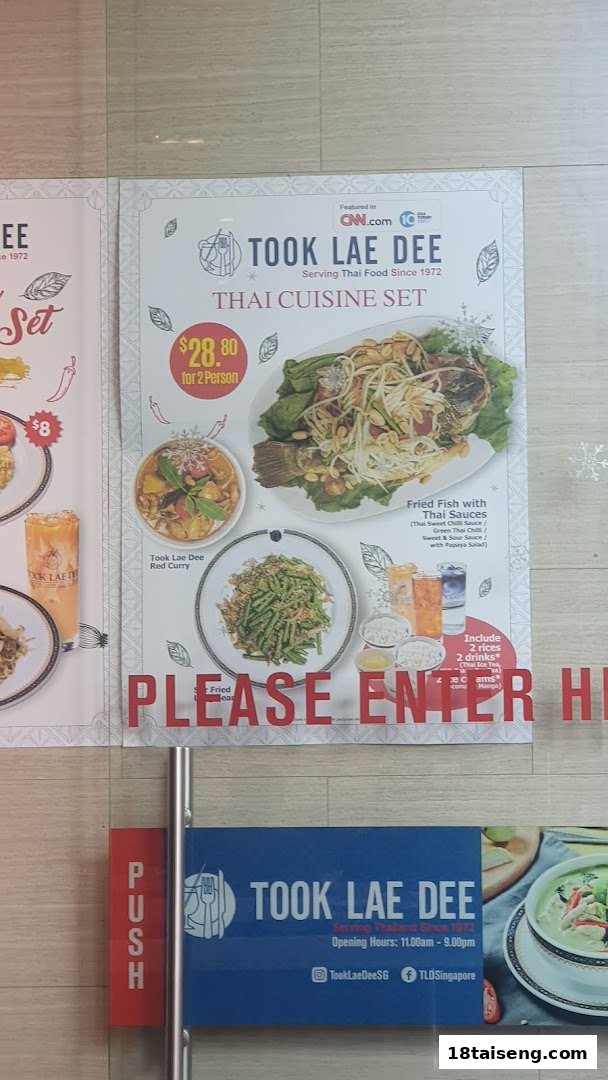 Promotional posters for Took Lae Dee's Thai Cuisine Set, featuring dishes and pricing, at the shop entrance.