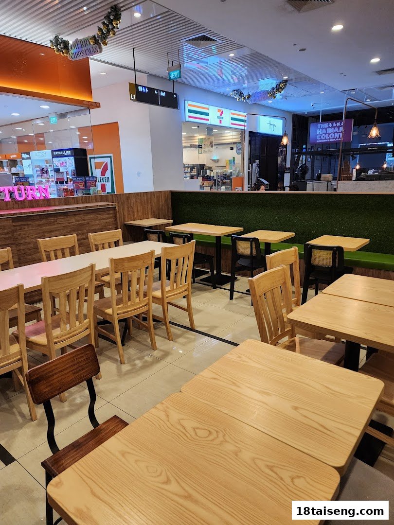 A brightly lit, empty dining area with light wooden tables and chairs, ready for customers.