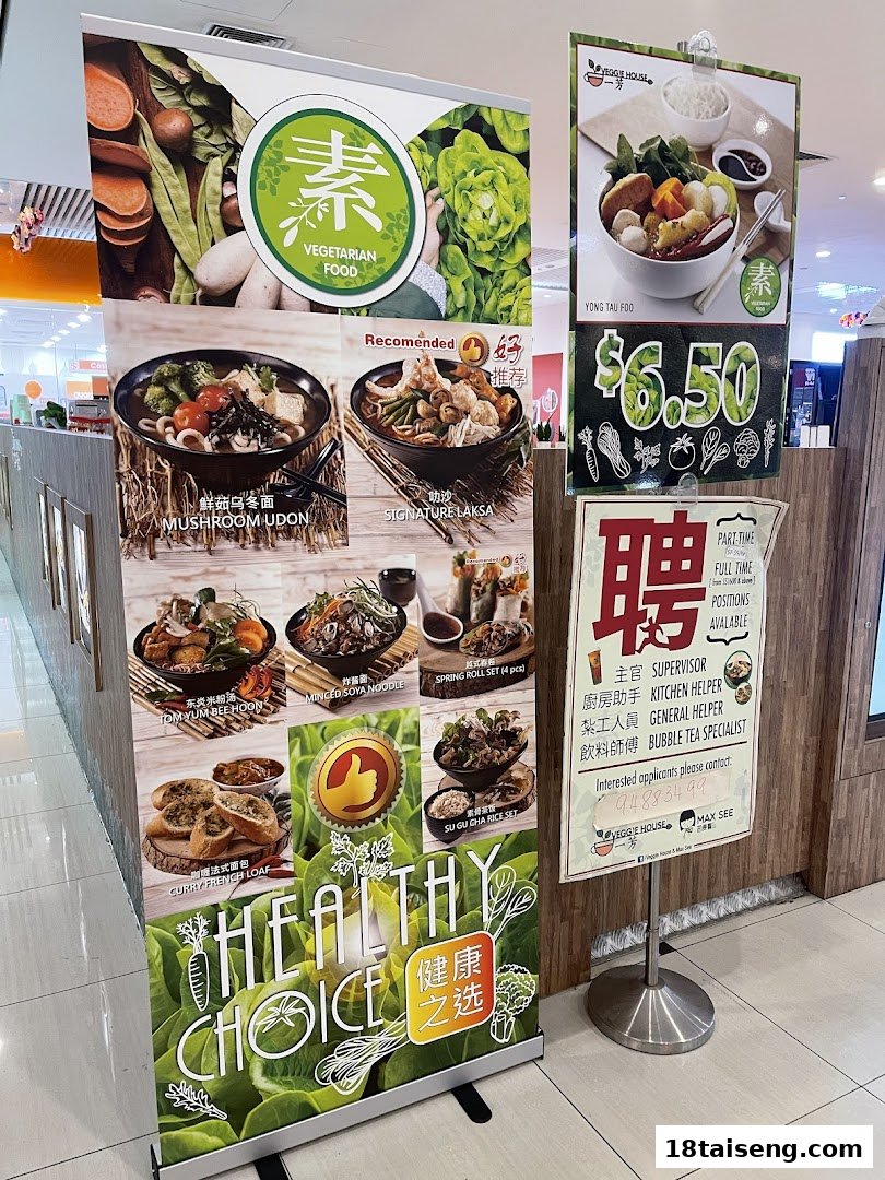Promotional banners for Veggie House Vegetarian showcasing healthy food options and a job recruitment sign.