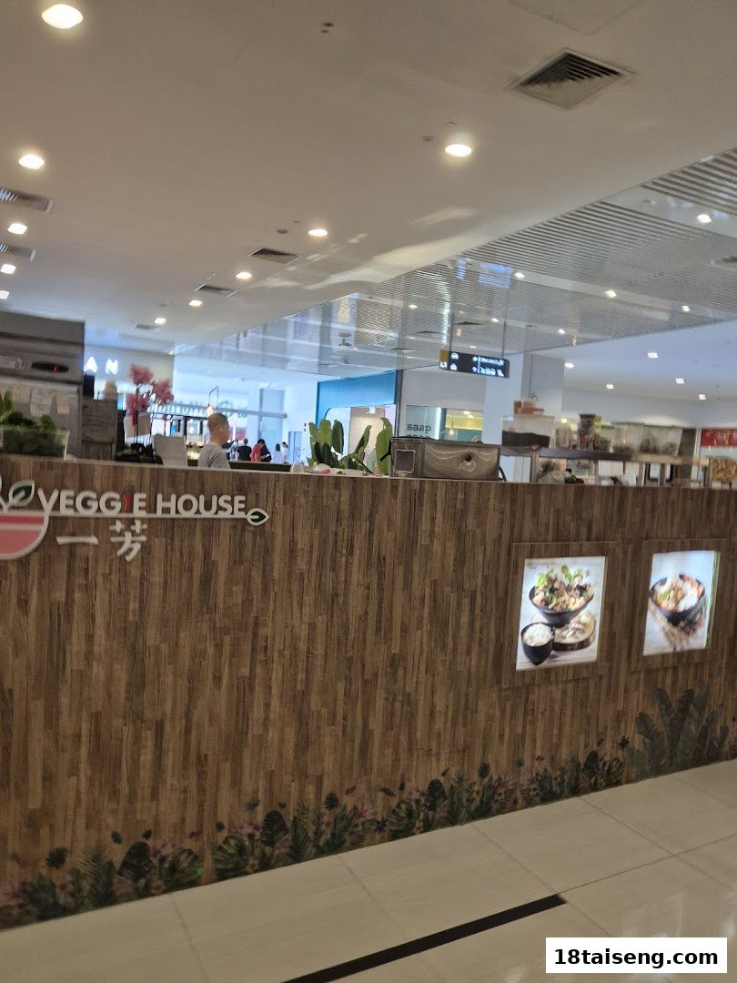 The front counter of Veggie House Vegetarian, showcasing its branding and inviting atmosphere.