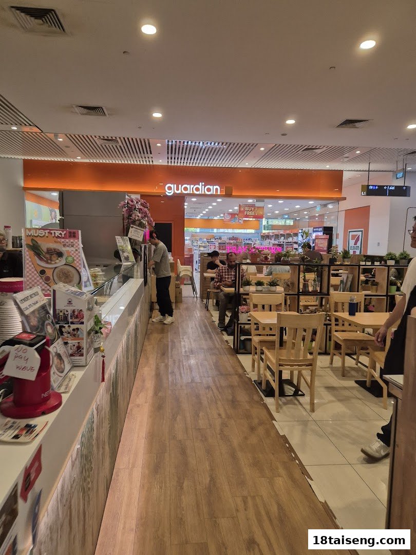 An interior view of Veggie House Vegetarian, featuring a service counter, dining area with wooden tables, and customers.