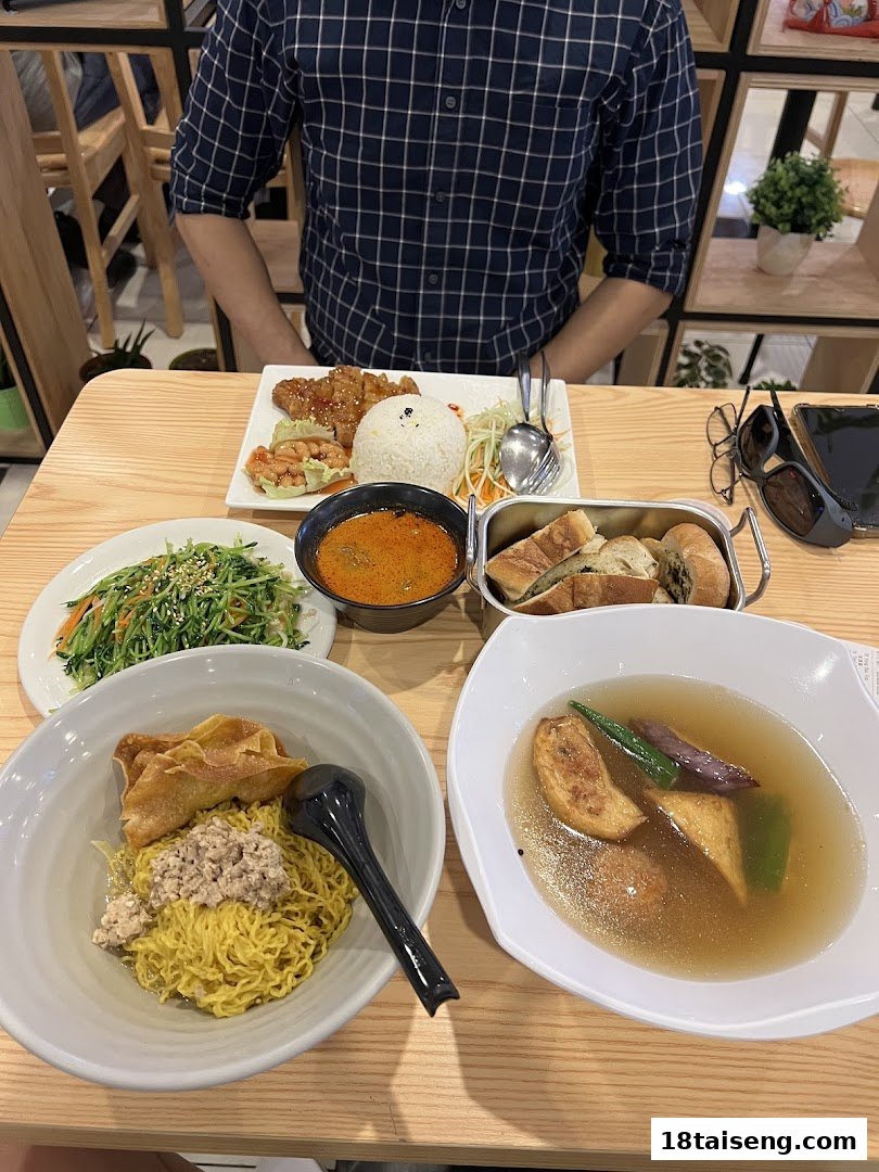 A table laden with various delicious vegetarian dishes, including noodles, soup, and rice, ready for dining.