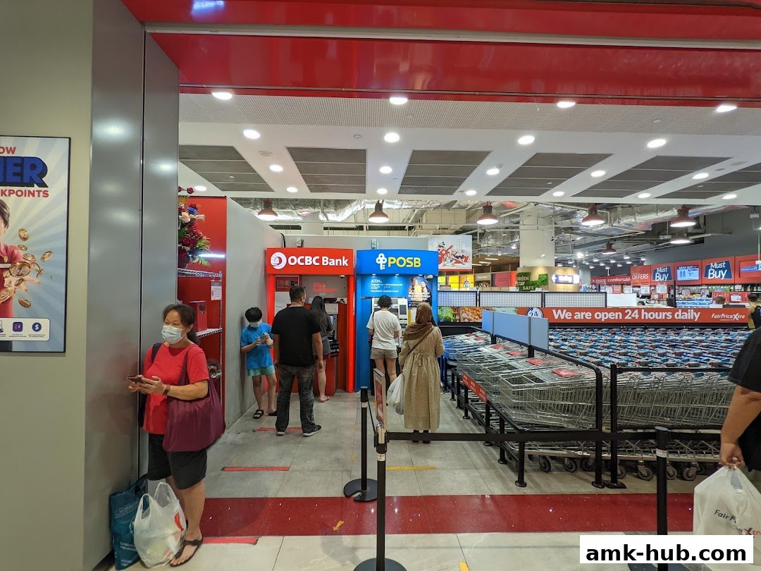 People queuing at POSB and OCBC ATMs inside a FairPrice Xtra supermarket.