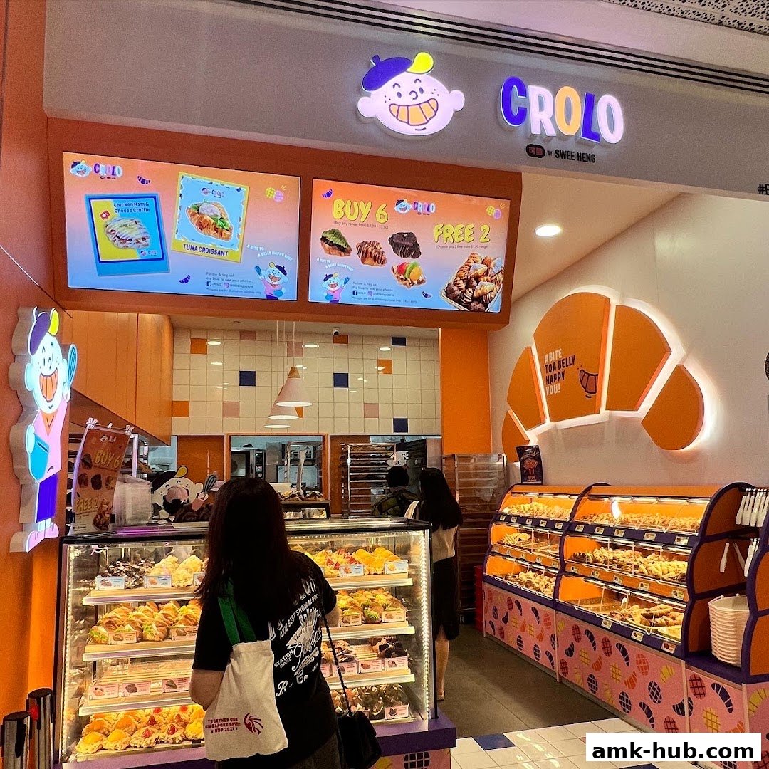 A brightly lit bakery shop with displays of pastries and a promotional board.
